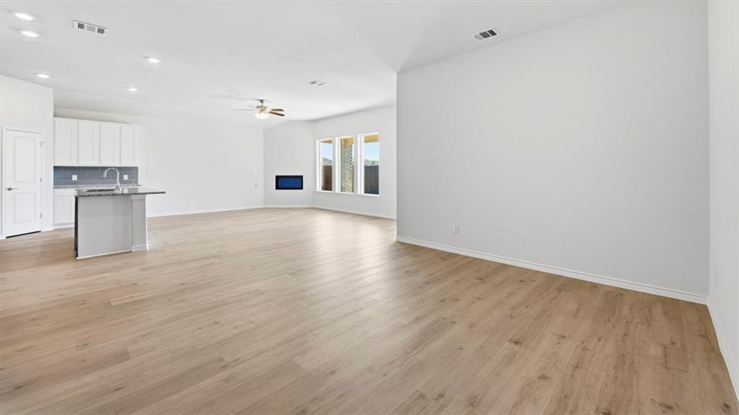 Unfurnished living room with light wood-type flooring, a ceiling fan, and recessed lighting