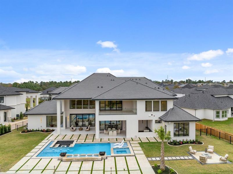 Take in the stunning back view and the sunken fire pit adjacent to the pool, creating a tranquil and inviting space to relax and unwind.