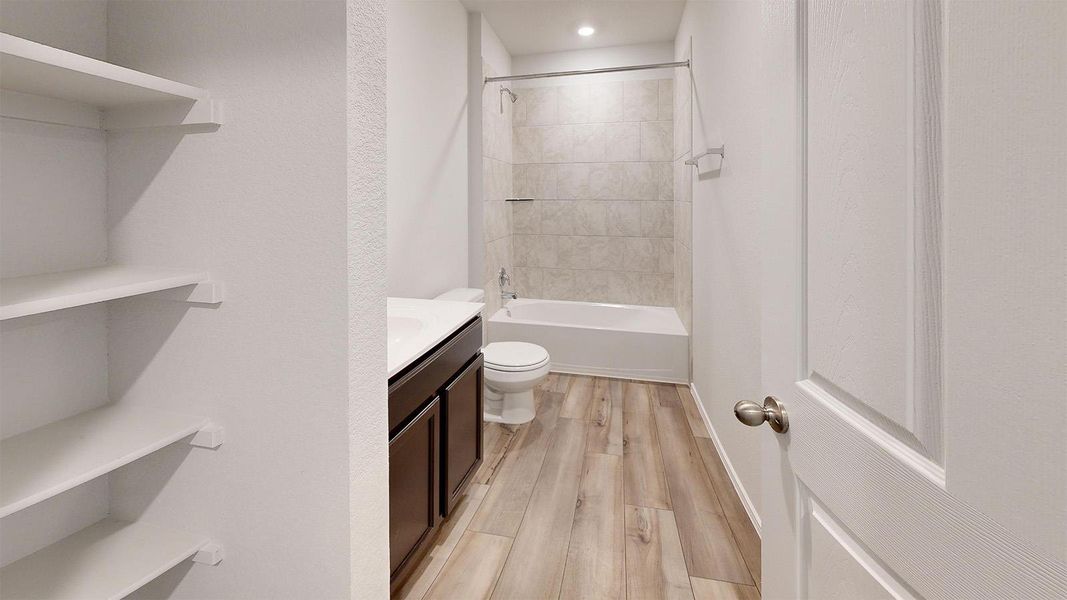 Full bath featuring vanity, light wood finished floors, and shower / washtub combination