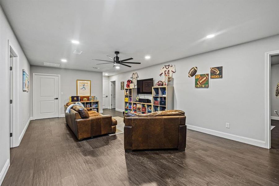 Living area with dark wood-style floors, ceiling fan, and recessed lighting Living area with dark wood-style floors, ceiling fan, and recessed lighting