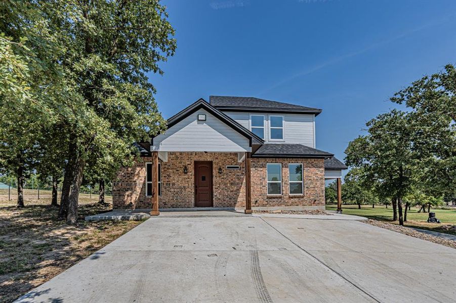 View of front of house with covered porch, brick siding, and driveway View of front of house with covered porch, brick siding, and driveway