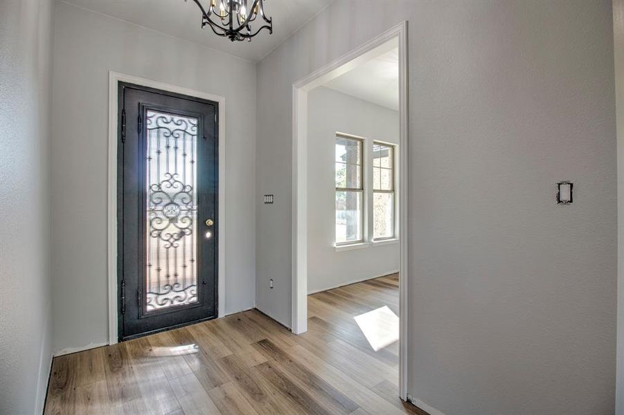 Entrance foyer featuring light hardwood / wood-style flooring and a notable chandelier