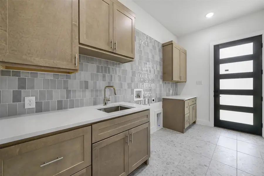 Kitchen with tasteful backsplash, light countertops, and recessed lighting