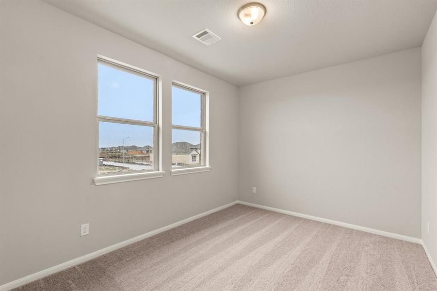 Your secondary bedroom features plush carpet, fresh paint, closet, and a large window that lets in plenty of natural lighting.