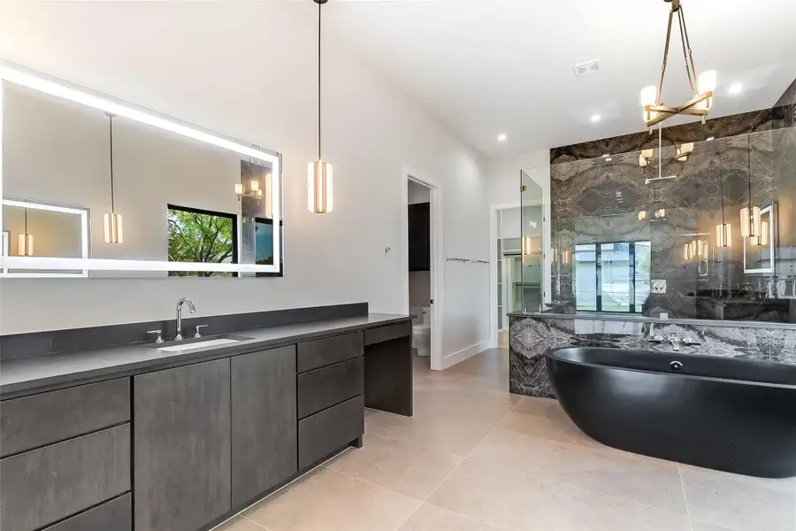 Full bath featuring a freestanding tub, a stall shower, vanity, tile patterned flooring, and toilet Full bath featuring a freestanding tub, a stall shower, vanity, tile patterned flooring, and toilet