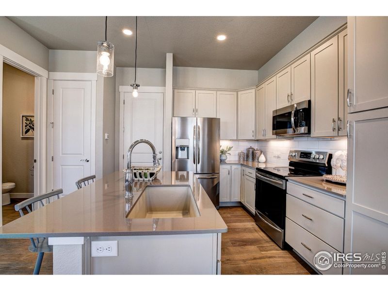 Kitchen w/ large island, ready to personalize. Photos of a previously built model.