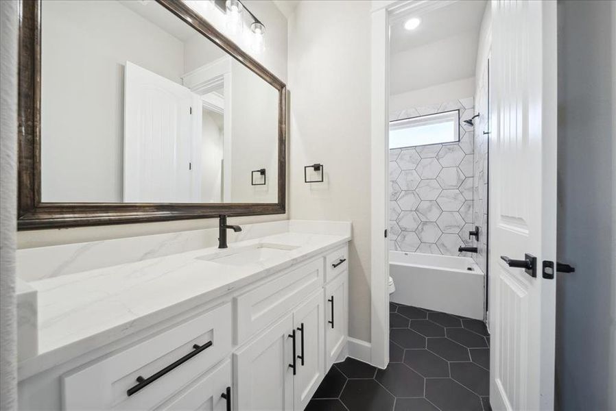 Full bathroom with tile patterned flooring, vanity, toilet, and tiled shower / bath