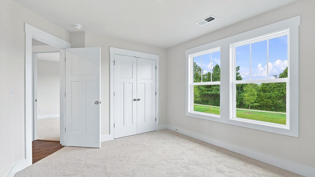 Notable bedroom offering soft carpet, a walk-in closet, and expansive windows