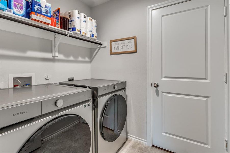 Laundry area featuring washer and dryer and light tile patterned floors