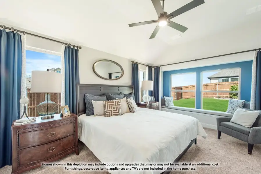 Bedroom with vaulted ceiling, ceiling fan, window seat, and blue accent wall Bedroom with vaulted ceiling, ceiling fan, window seat, and blue accent wall