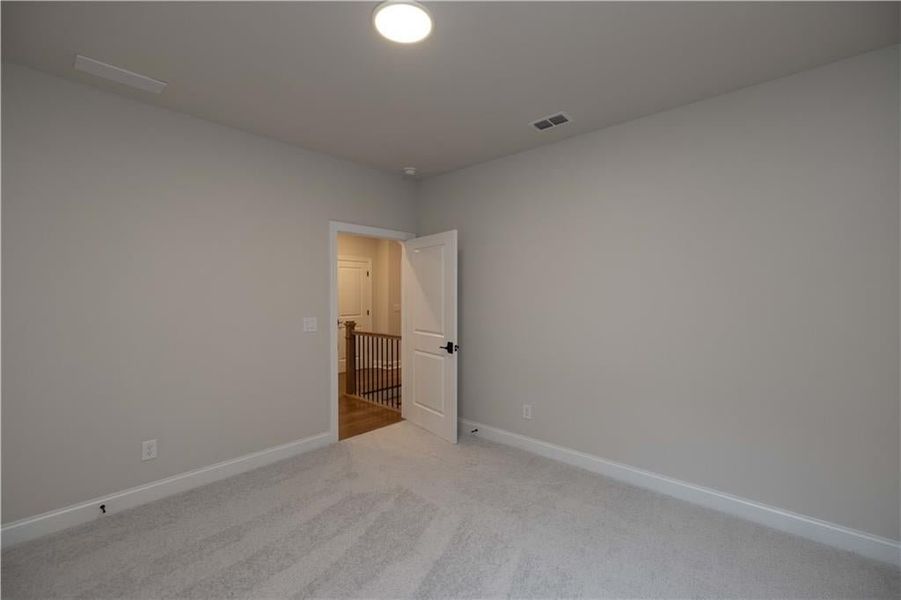 Empty room featuring baseboards and light colored carpet