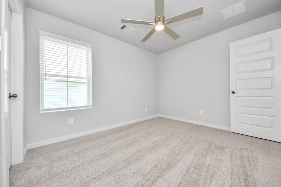 Secondary bedroom features plush carpeting, large windows that let in plenty of natural light, bright paint, and spacious closets. Sample photo of completed home with similar floor plan. Actual colors and selections may vary. Secondary bedroom features plush carpeting, large windows that let in plenty of natural light, bright paint, and spacious closets. Sample photo of completed home with similar floor plan. Actual colors and selections may vary.