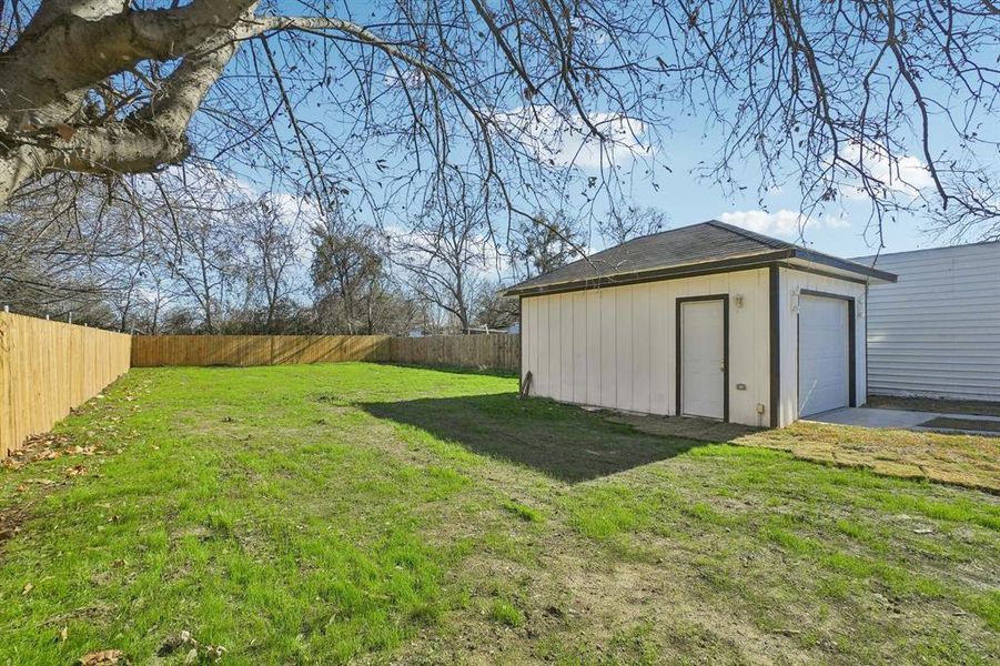 View of yard featuring an outdoor structure and a garage