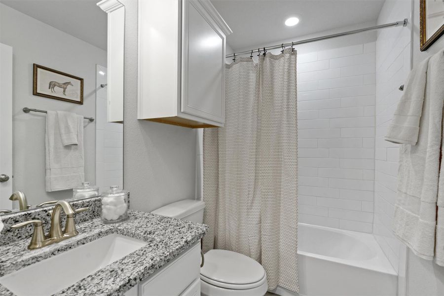 Full bathroom featuring shower / bath combination with curtain and vanity