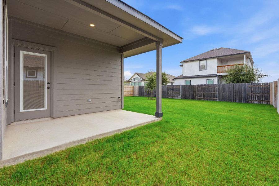 A spacious yard provides ample room for outdoor activities, complementing the covered patio ideal for relaxation.