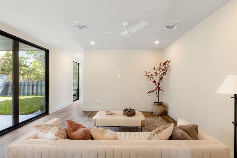 Living area with wood finished floors, recessed lighting, and a ceiling fan