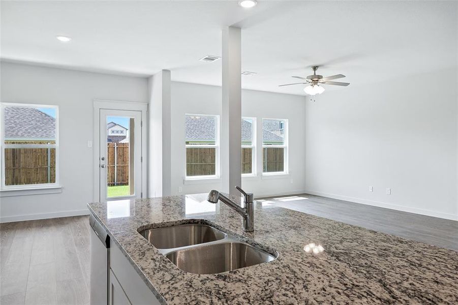 Kitchen featuring light wood-type flooring, light stone countertops, dishwasher, ceiling fan, and recessed lighting Kitchen featuring light wood-type flooring, light stone countertops, dishwasher, ceiling fan, and recessed lighting
