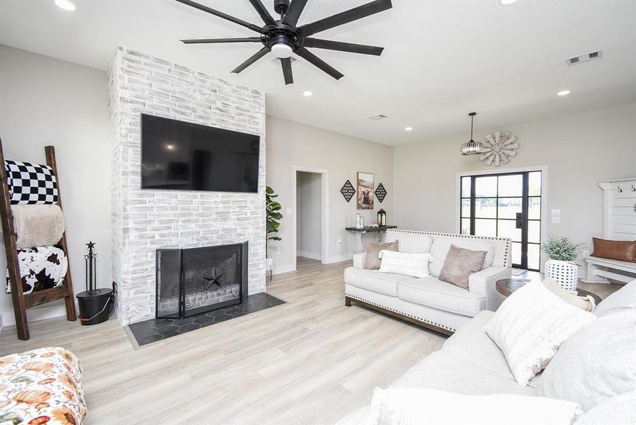 Living room with wood burning fireplace featuring a gas start