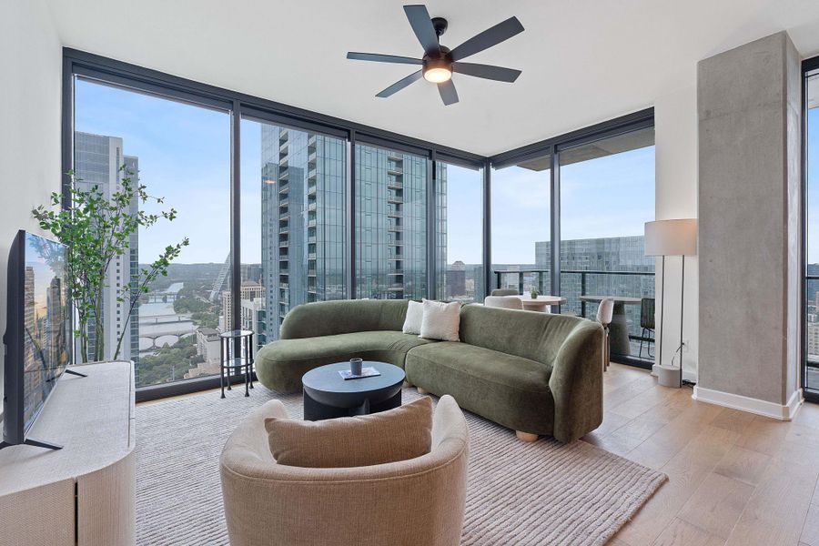 Representative Photo. Open Concept living room with 7.5" wide Bella Cera hardwood flooring, recessed lighting, ceiling fan, and a balcony off the living room with a North West view