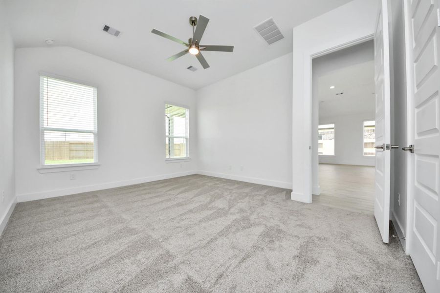 Come and unwind after a long day in this magnificent primary suite! This spacious room features plush carpet, warm paint, high ceilings and large windows with privacy blinds.