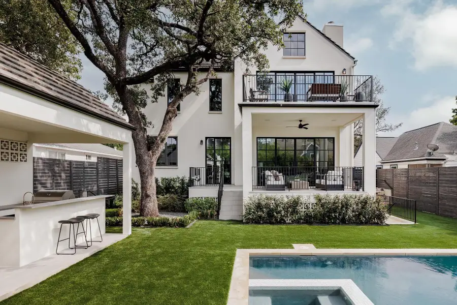 A true backyard retreat featuring a resort-style pool, spa, and outdoor kitchen surrounded by lush landscaping and architectural lighting. A true backyard retreat featuring a resort-style pool, spa, and outdoor kitchen surrounded by lush landscaping and architectural lighting.