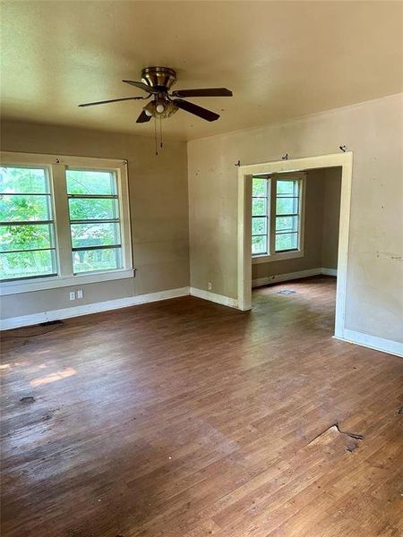 Empty room with wood finished floors and a ceiling fan Empty room with wood finished floors and a ceiling fan