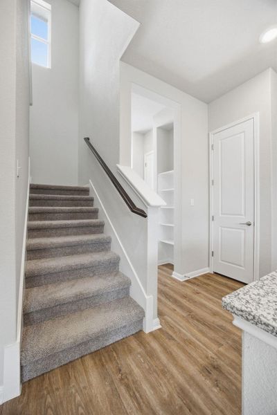 Staircase with wood finished floors and baseboards