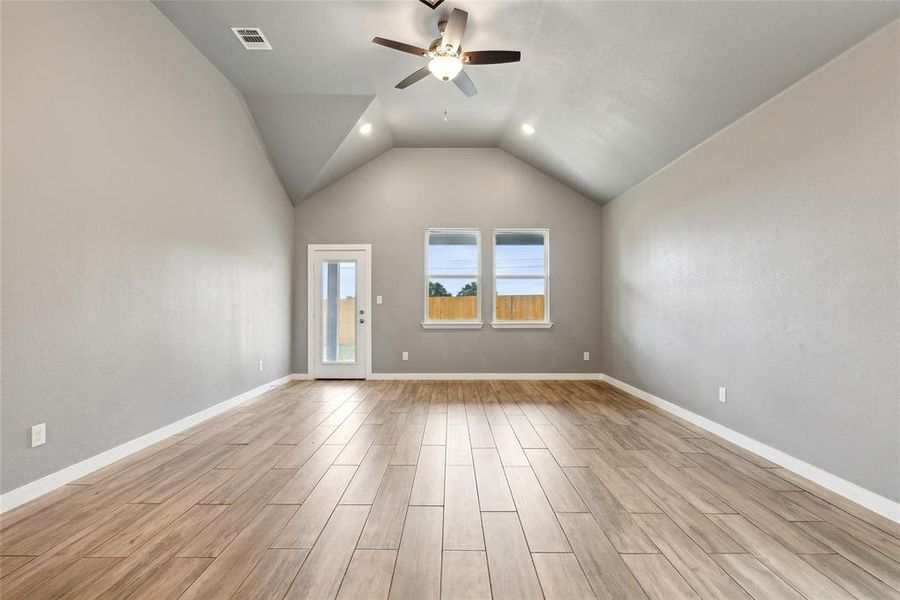 Empty room with lofted ceiling, light hardwood / wood-style flooring, and ceiling fan