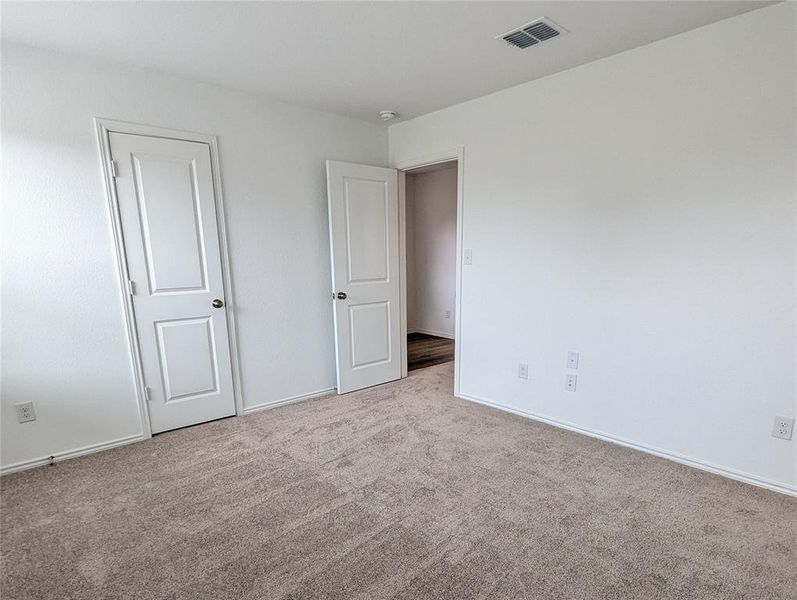 A well-maintained carpeted room offers versatile living possibilities.