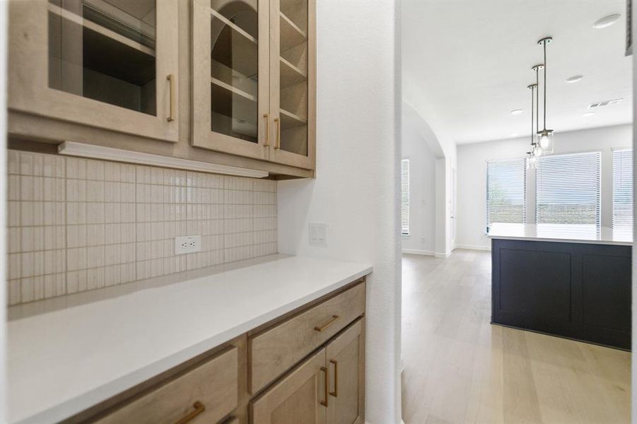 Built-in cabinetry with glass-front uppers and under-cabinet lighting Built-in cabinetry with glass-front uppers and under-cabinet lighting