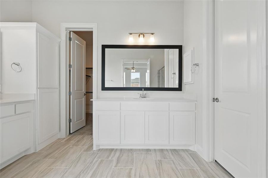 Bathroom featuring a ceiling fan, vanity, and a stall shower