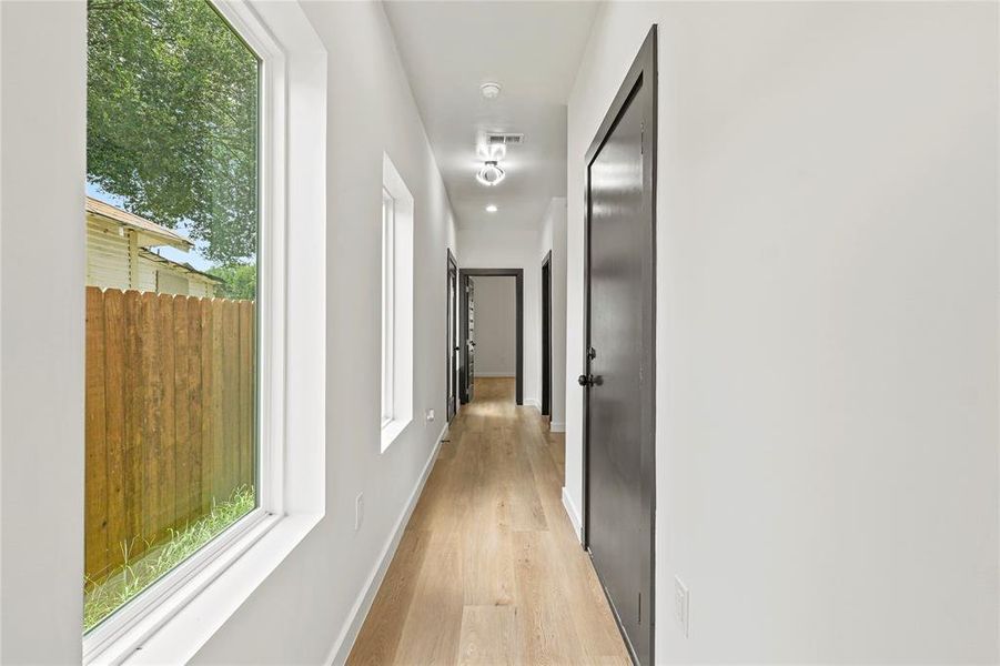 Hallway featuring light wood-style flooring and baseboards Hallway featuring light wood-style flooring and baseboards