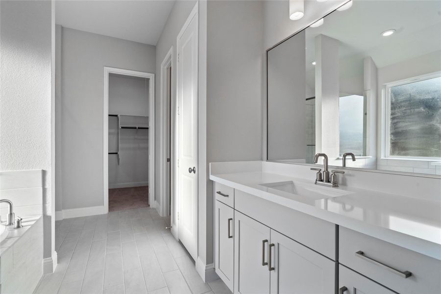 Modern primary bath features dual vanities with sleek cabinetry, quartz countertop, and brushed nickel fixtures for a truly contemporary feel.
