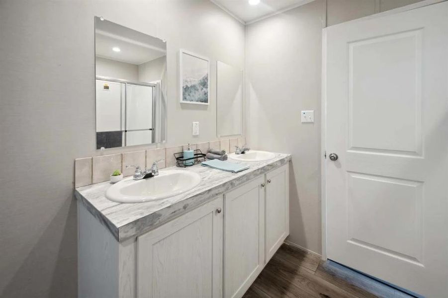 Bathroom with hardwood / wood-style floors, vanity, tasteful backsplash, and walk in shower