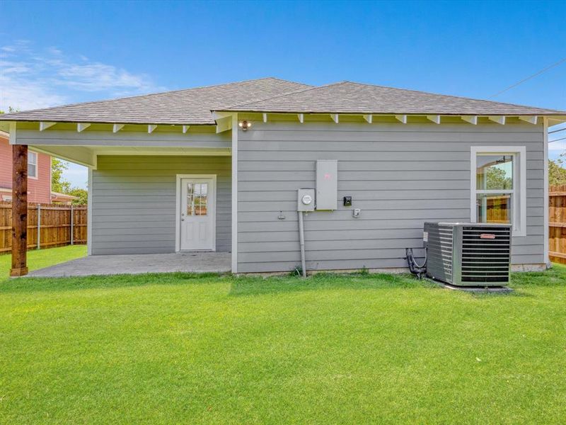 Rear view of house with central AC unit, a patio area, and a shingled roof Rear view of house with central AC unit, a patio area, and a shingled roof