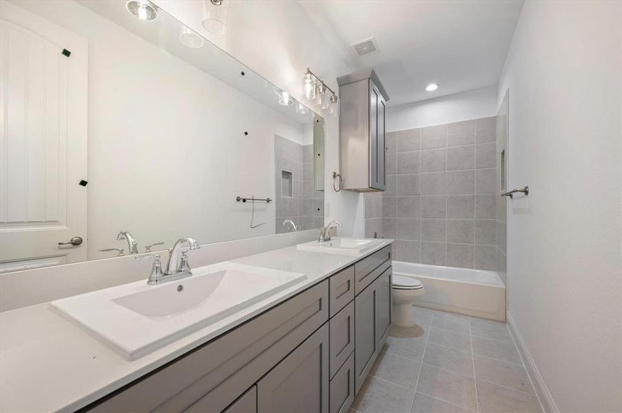 Bathroom featuring vanity, toilet, and tile patterned flooring