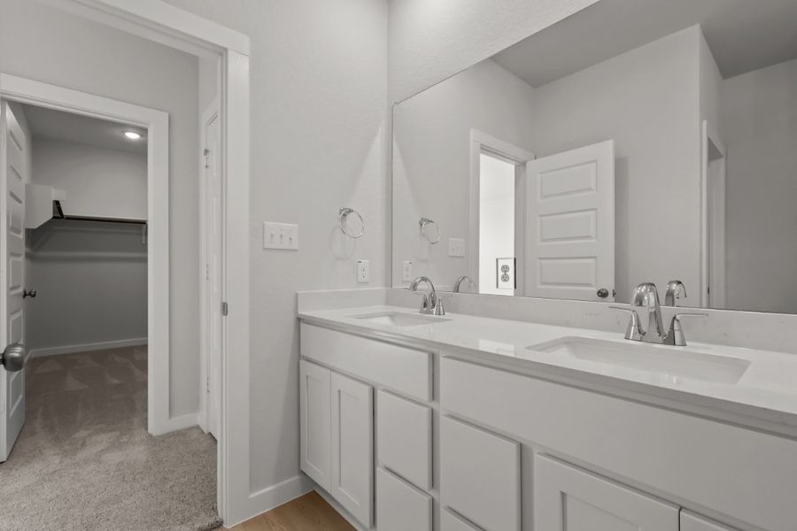 A bathroom with white cabinets.