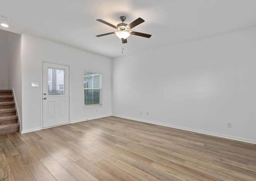 Open family room, with the staircase leading upstairs and a door leading outside.