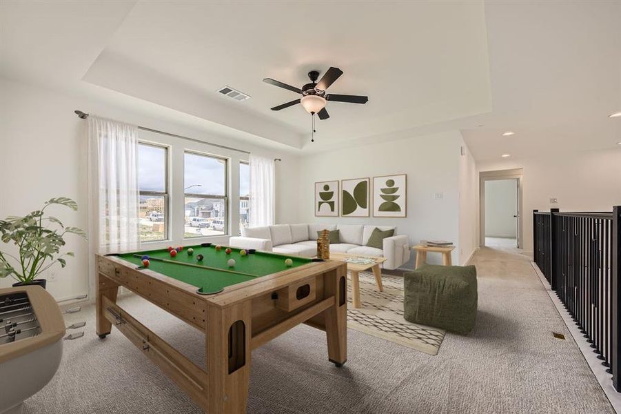 Virtually staged photo Game room with a tray ceiling, light carpet, recessed lighting, and a ceiling fan Virtually staged photo Game room with a tray ceiling, light carpet, recessed lighting, and a ceiling fan