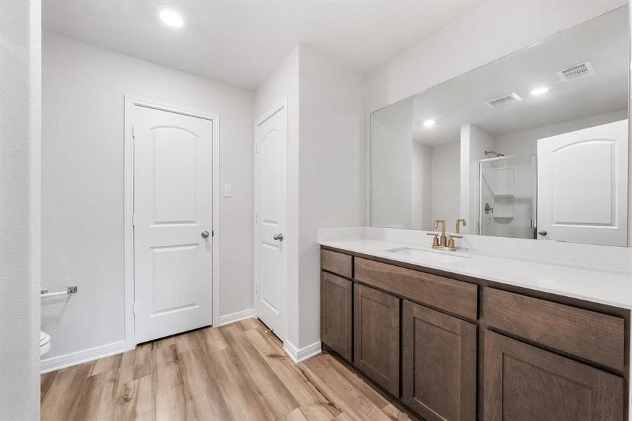 Bathroom featuring toilet, walk in shower, vanity, and wood-type flooring