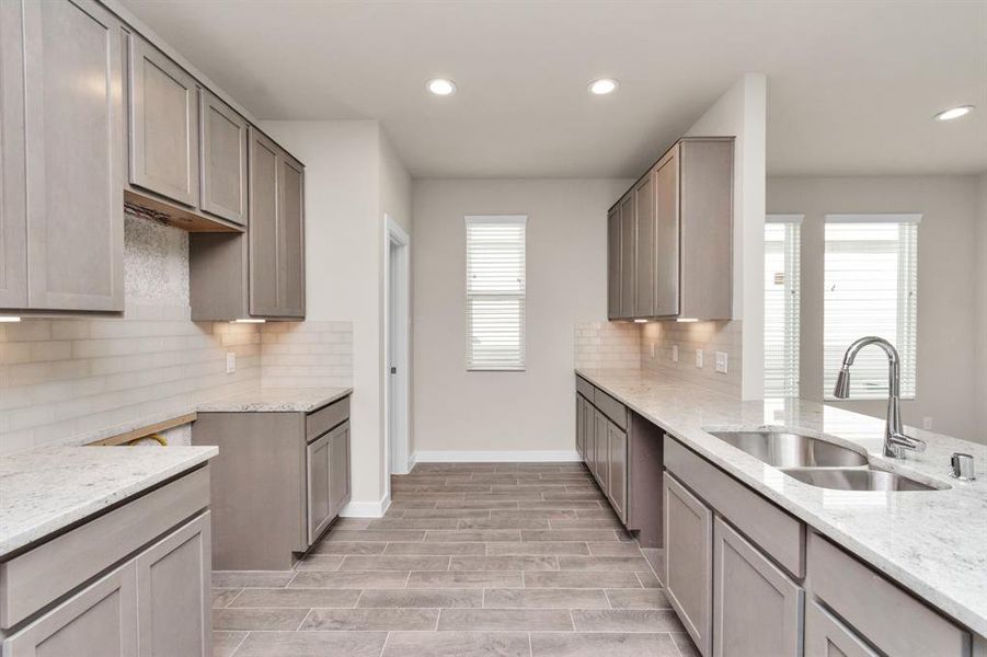 This kitchen is by far any chef’s dream! This spacious kitchen features high ceilings, slate wood cabinets, granite countertop, SS appliances, modern tile backsplash, recessed lighting, and extended counter space. Sample photo of completed home with similar floor plan. As-built interior colors and selections may vary.