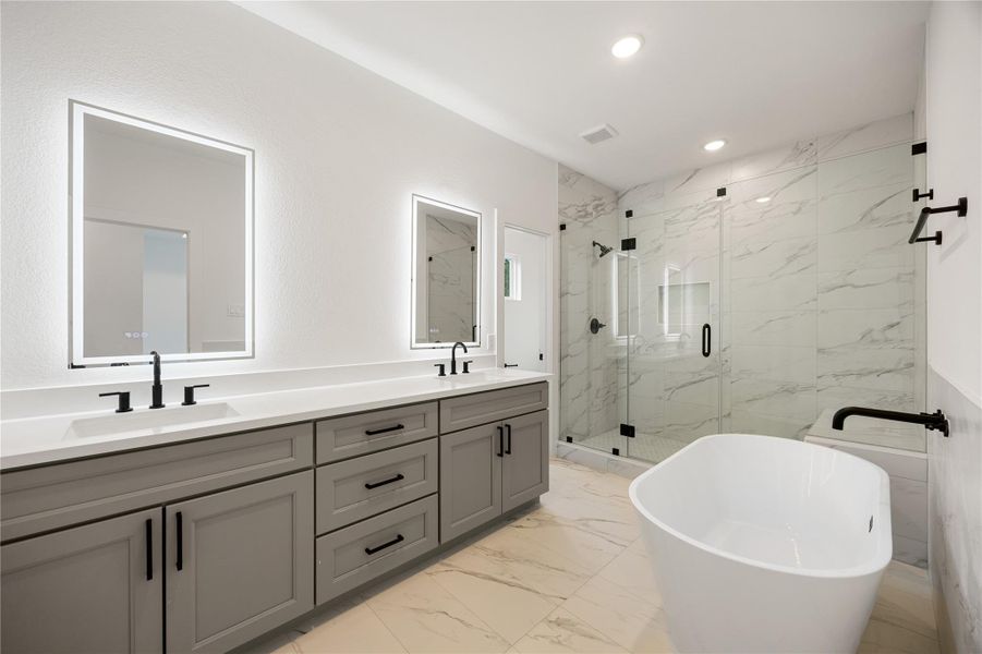 This move-in ready primary bathroom offers plenty of space to share. The stained cabinetry with light countertops and dual sinks are enhanced by back-lit modern mirrors - perfect to get ready for your day! The modern tile flooring, soaking tub and oversized walk-in shower with seat, sleek dark and modern finishes complete this gorgeous primary bathroom for a polished look.