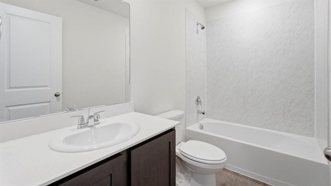 Bathroom with vanity, tub / shower combination, and light wood-type flooring