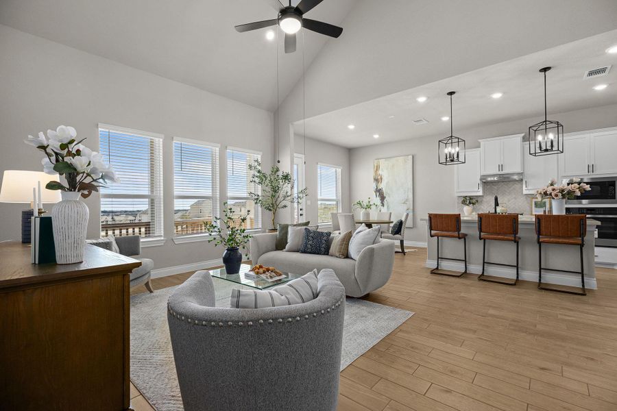 Living area with light wood-type flooring, high vaulted ceiling, recessed lighting, and a ceiling fan
