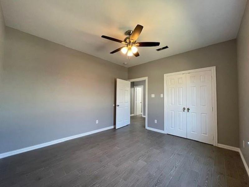 3rd bedroom featuring wood-style flooring, a closet, ceiling fan, and baseboards 3rd bedroom featuring wood-style flooring, a closet, ceiling fan, and baseboards