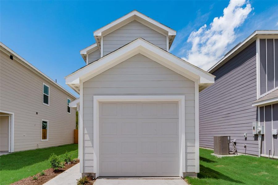 Garage featuring a lawn and cooling unit