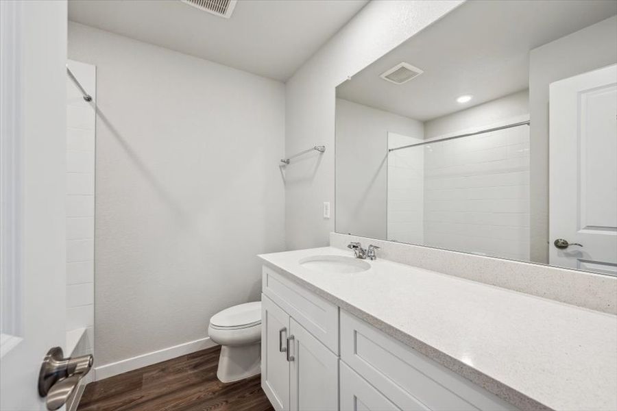 A bathroom with a tub sink and toilet.