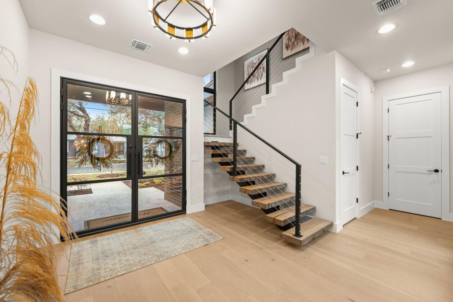 Foyer featuring stairs, light wood-style floors, and recessed lighting