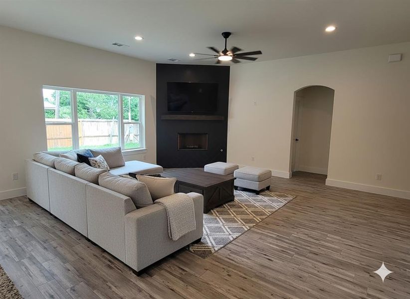 Spacious living area featuring wood-look flooring, recessed lighting, and a contemporary ceiling fan