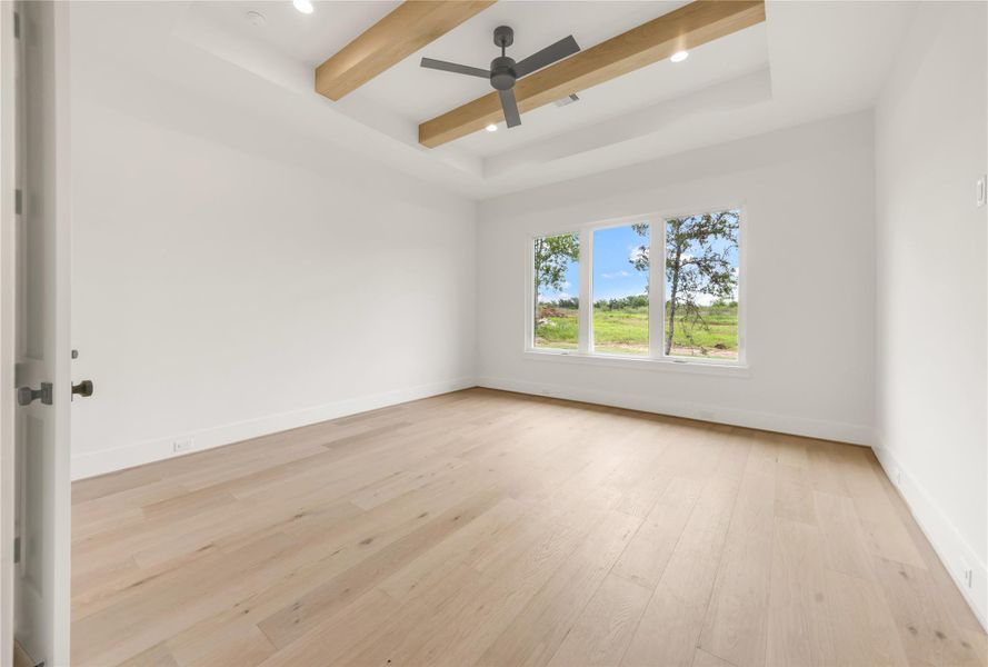 Empty room featuring ceiling fan, recessed lighting, beamed ceiling, light wood-type flooring, and a tray ceiling